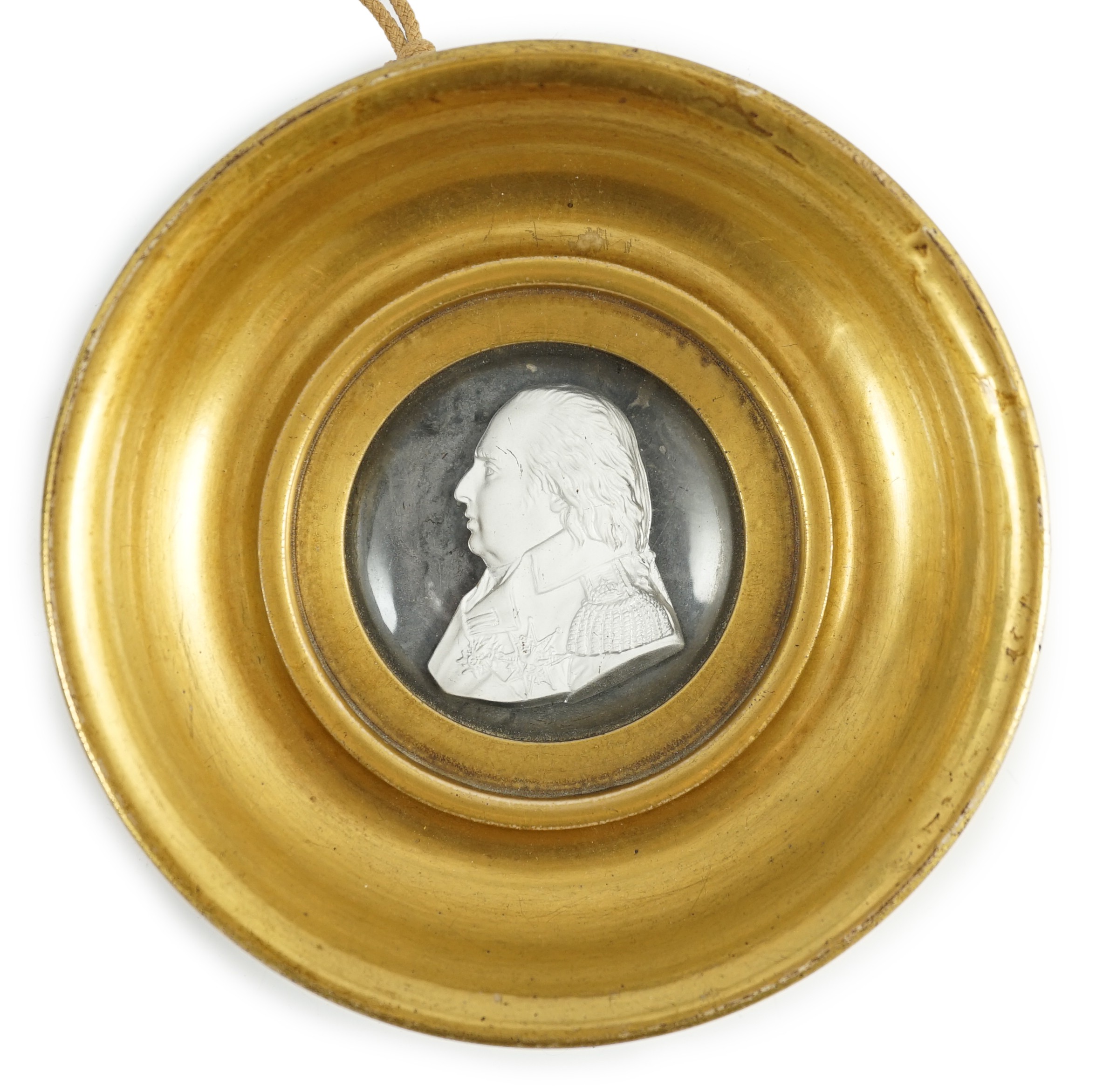 A Louis XVIII glass sulphide portrait plaque, in a gilded porcelain frame, c.1820, 14.5cm diameter